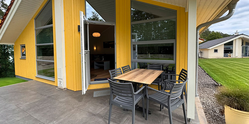 Gelbes Holzhaus mit Terrasse